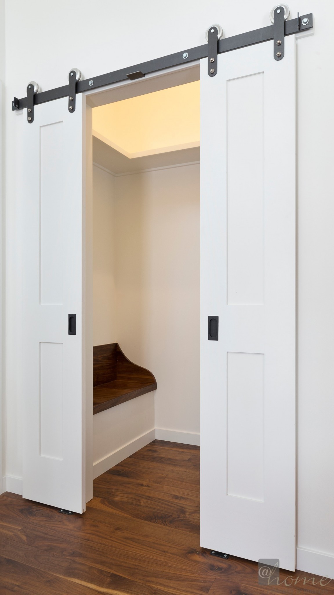 Foyer “Coat Room” featuring popular barn doors & a boot bench. Build out by Jenema builders.